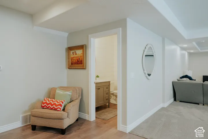 Wood-finish flooring, white trim, recessed lighting, and a bathroom with a vanity