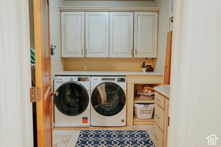 Laundry area featuring built-in cabinetry, a countertop, and tile flooring