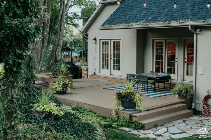 Expansive outdoor deck with built-in seating, multiple access points to the interior, and a flagstone patio