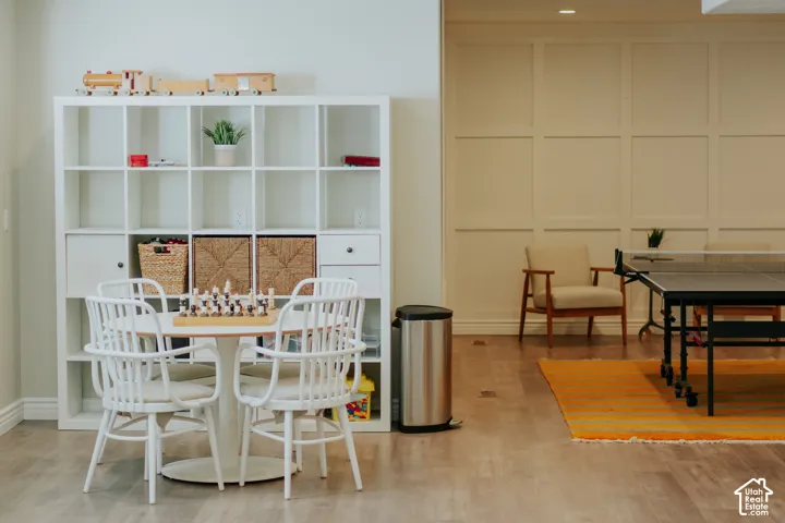 Wood-finish flooring, recessed lighting, built-in shelving unit, and wainscoting wall detail