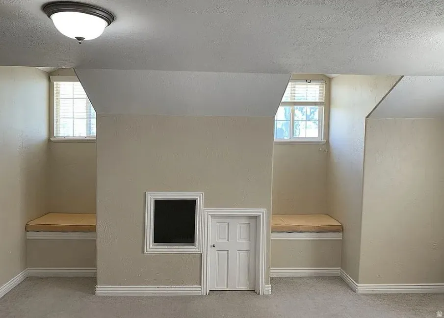 Recessed window nooks with built-in bench seating, architectural ceiling angles, and a flush-mount ceiling light fixture