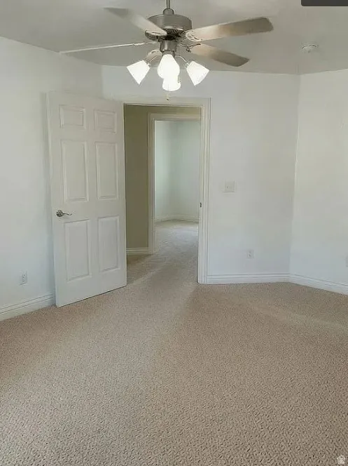 Master Bedroom: Neutral-tone wall paint, textured carpeting, contemporary ceiling fan with integrated lighting, and painted interior doors with lever handles