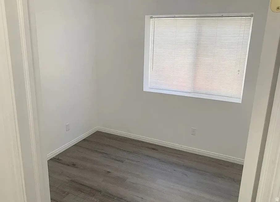 Window with horizontal blinds, LPV finish flooring, and white wall paint