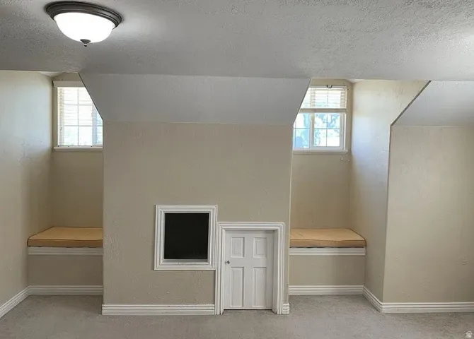 Recessed window nooks with built-in bench seating, architectural ceiling angles, and a flush-mount ceiling light fixture