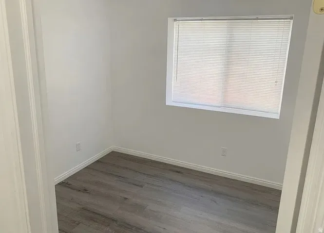 Window with horizontal blinds, LPV finish flooring, and white wall paint
