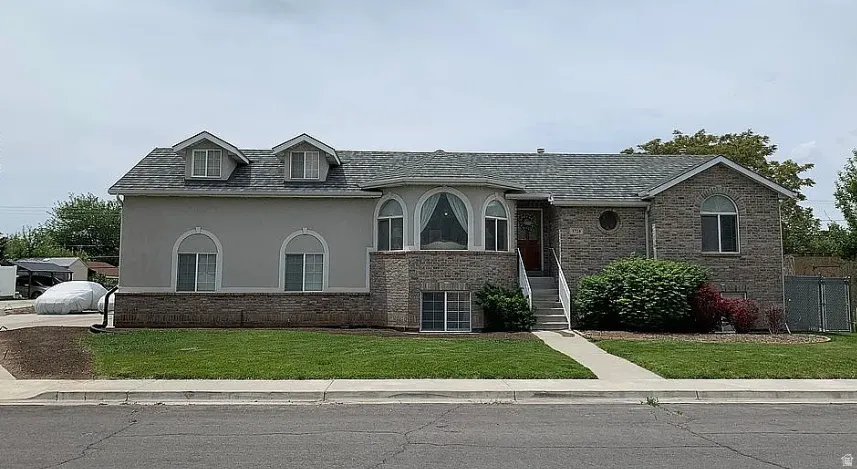 Brick and stucco exterior with multiple arched windows and a prominent bay window