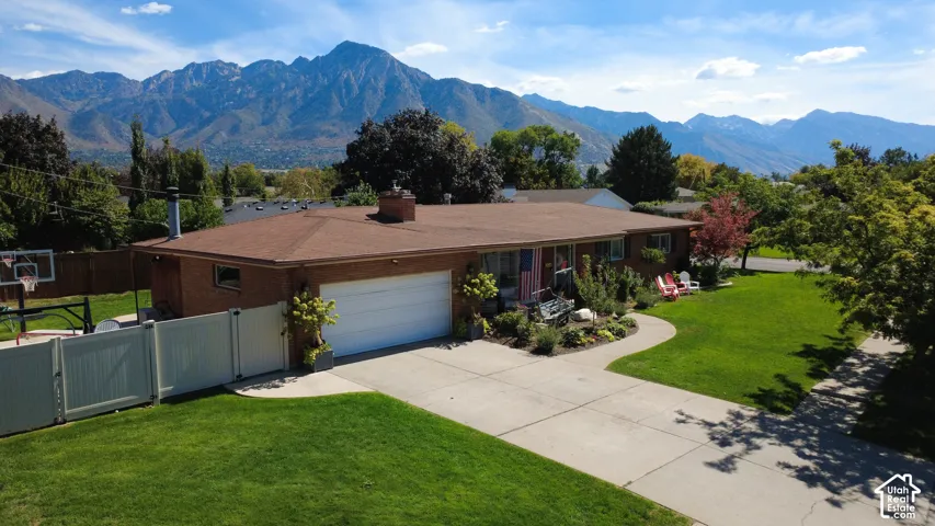 Brick exterior residence with an attached two-car garage, mature landscaping, and a manicured front lawn