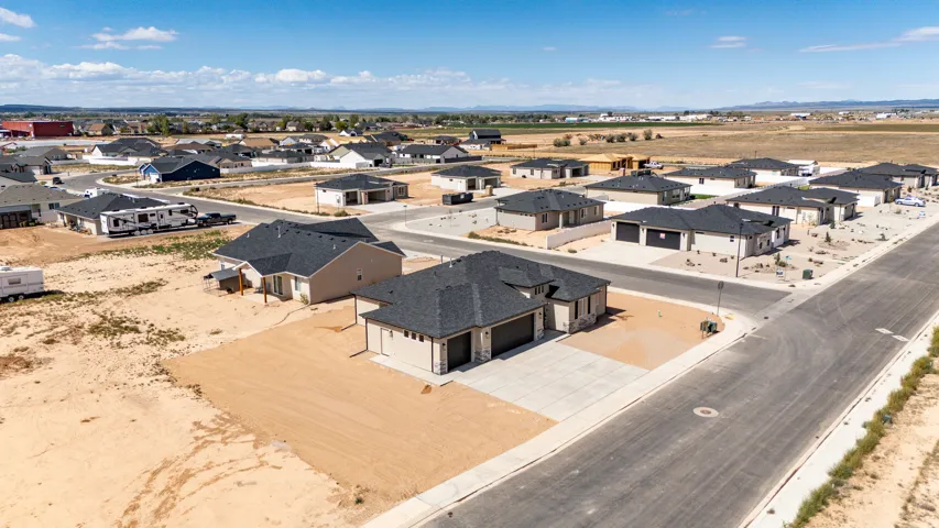 Newly constructed residential neighborhood featuring modern single-story homes, paved streets, and concrete driveways
