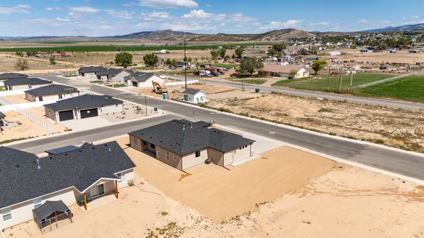Newly constructed homes featuring a contemporary design, attached garages, and paved roadways
