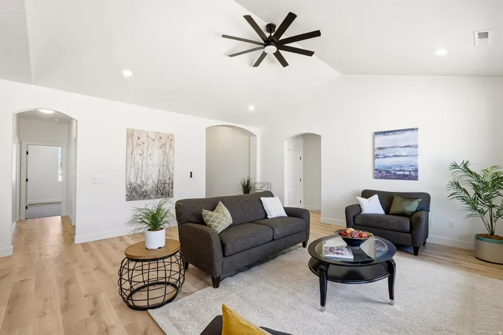 Vaulted ceiling with a contemporary ceiling fan, recessed lighting, wood-finish flooring, and arched doorways