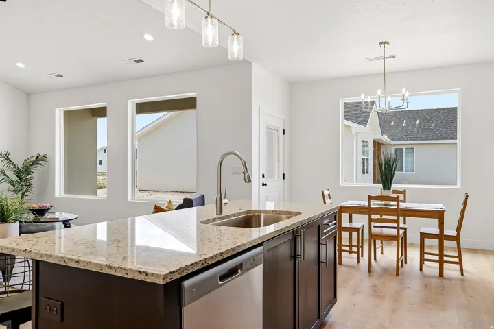 Kitchen island with stone countertop, stainless steel sink, and integrated dishwasher