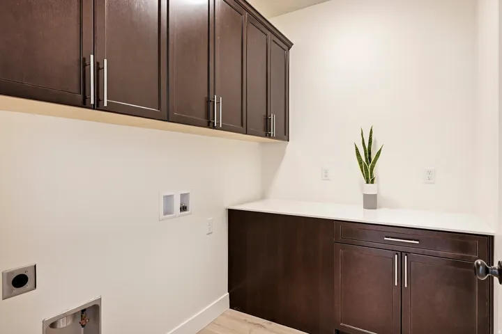 Dark wood-finish cabinetry, white countertops, and light wood-finish flooring
