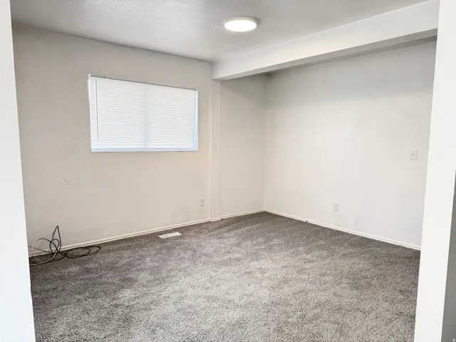Bright, open recreation room featuring neutral wall finishes, recessed ceiling lighting, and comfortable carpet flooring