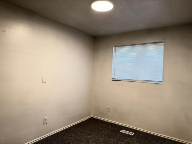 Recessed ceiling lighting, textured wall finish, window with horizontal blinds, wall-to-wall carpeting, and floor-level HVAC register
