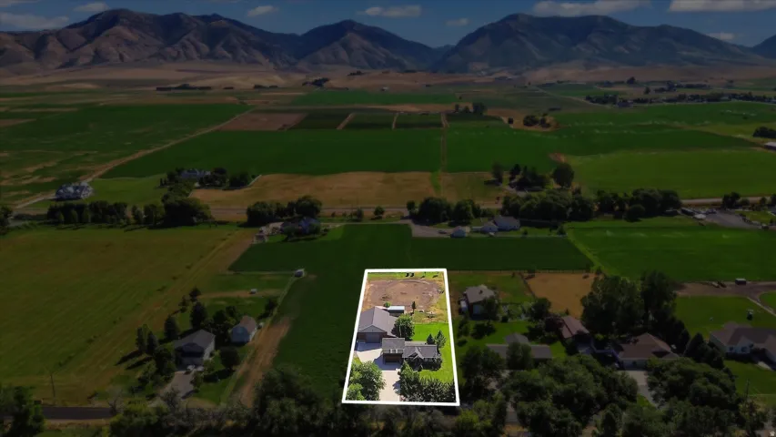 Expansive property featuring a single-story residence, detached garage, and substantial open land