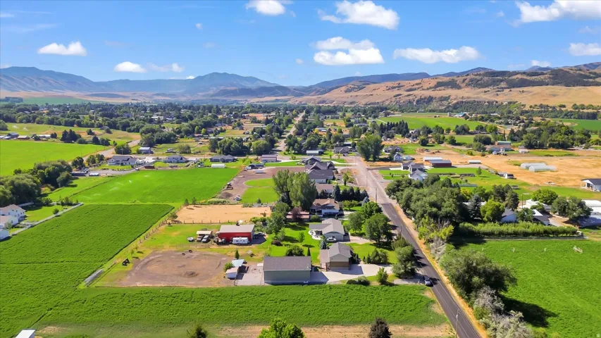 Expansive green fields with distant mountains under a blue sky