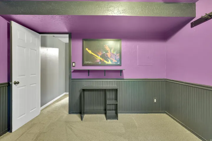 Room featuring wall-to-wall carpeting, beadboard wainscoting, and exposed ceiling beams