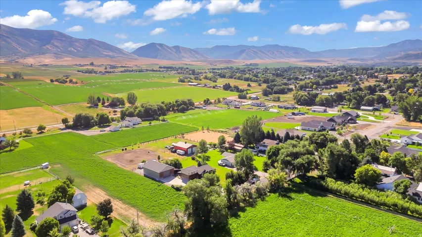 Expansive green landscape with distant mountains and scattered residential properties
