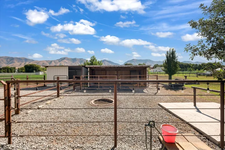 Expansive outdoor space featuring a gravel surface, perimeter fencing, and a circular in-ground fire pit