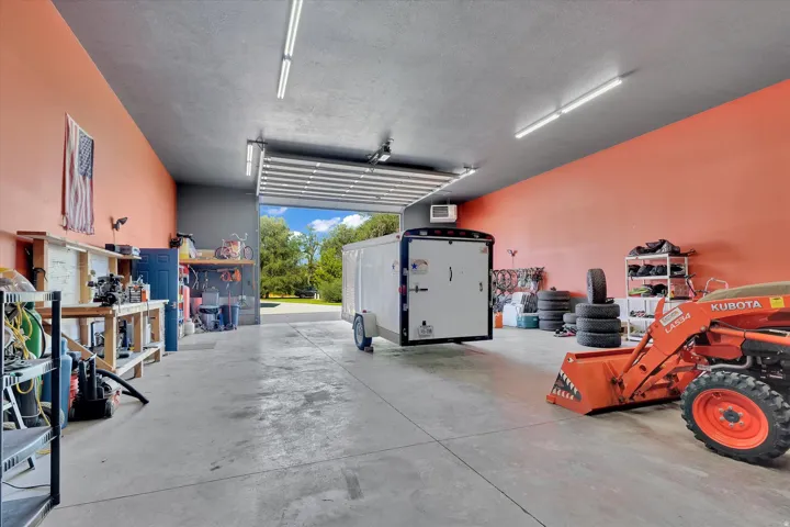 Spacious garage with high ceilings, concrete flooring, and ample lighting
