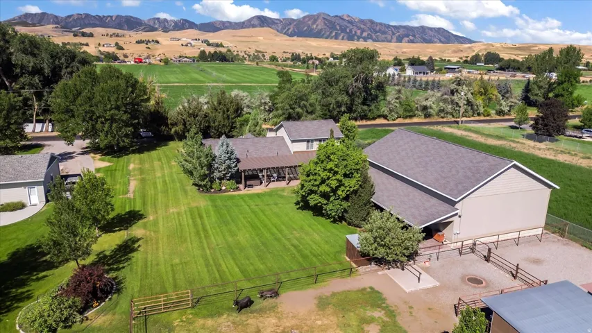 Expansive property featuring a large barn, fenced animal pens, and a covered patio structure