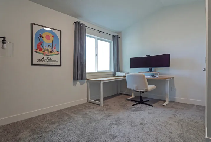 Plush carpeting, neutral wall tones, and a window with natural light