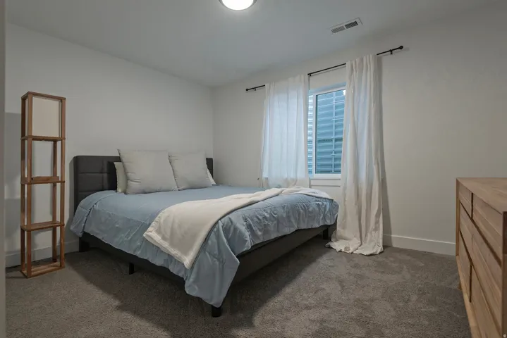 Soft gray carpeting, white walls, and a window with white trim