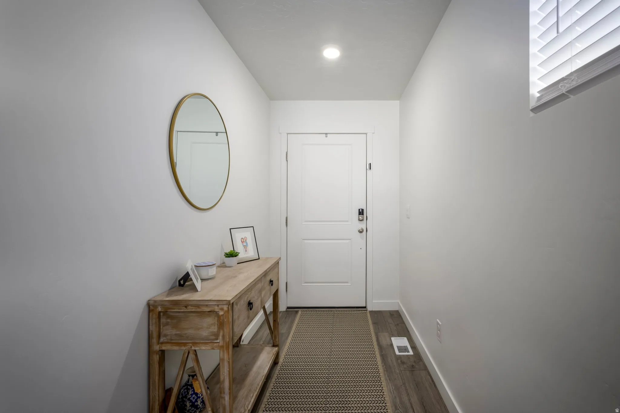 Entryway featuring light wood-finish flooring, recessed lighting, and a window with blinds