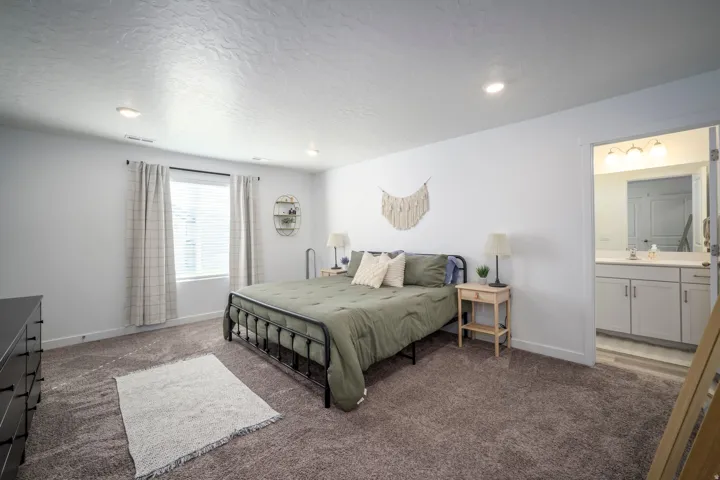 Master bedroom with recessed ceiling lighting, window with blinds, and carpeted flooring