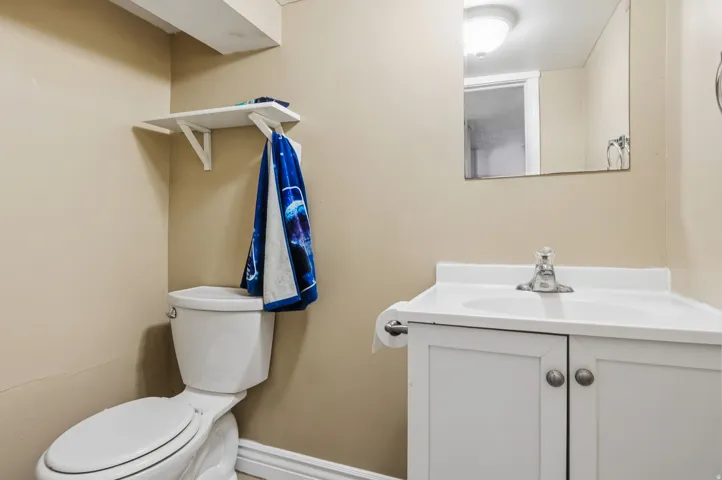 White vanity with cabinet storage, integrated sink, and wall-mounted mirror