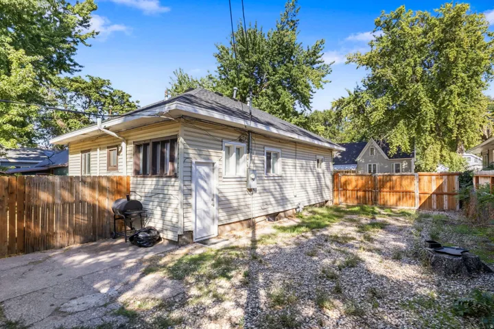 Rear exterior with horizontal siding, a gabled roof, and a wood privacy fence