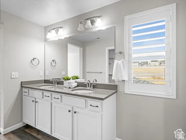 Dual vanity with white cabinetry, integrated sinks, and gray countertops