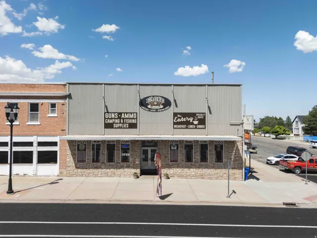 Commercial building featuring a stone facade, corrugated metal siding, and multiple storefront windows