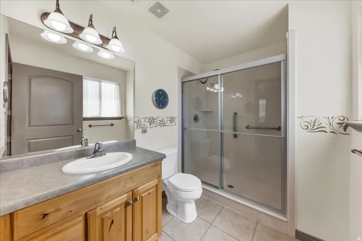 Wood-finish vanity with an integrated sink, broad countertop, and wall-mounted light fixture