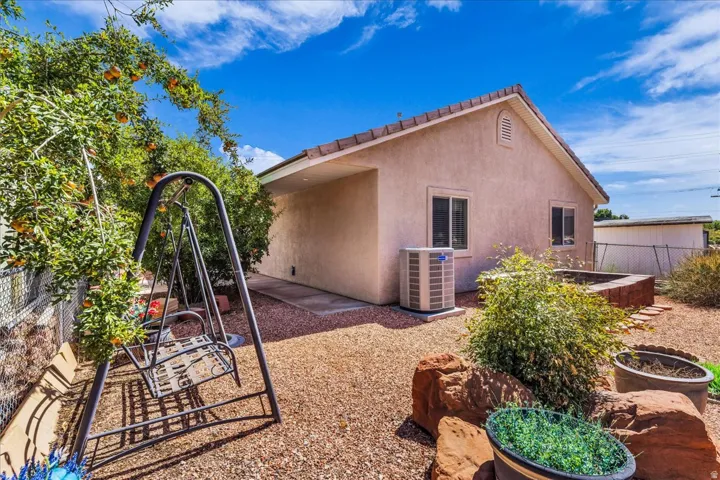 Stucco exterior with a tiled roof, gravel landscaping, and a raised planter box