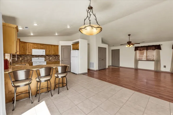 Open-concept living space featuring vaulted ceilings, wood-finish flooring, and recessed lighting