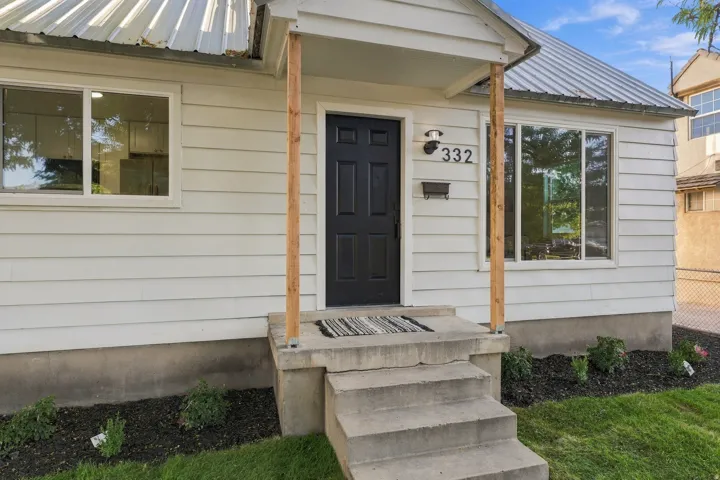 White siding exterior with a metal roof
