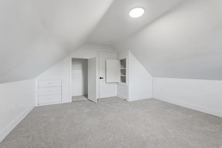 Built-in storage drawers, flush-mount lighting, and soft gray carpeting