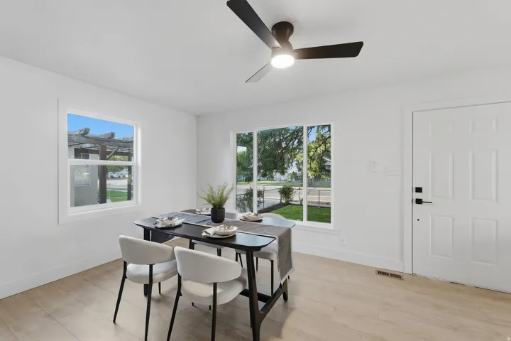 Recessed lighting, wood-finish flooring, white paneled door with matte black hardware, white walls, and a ceiling fan with integrated lighting