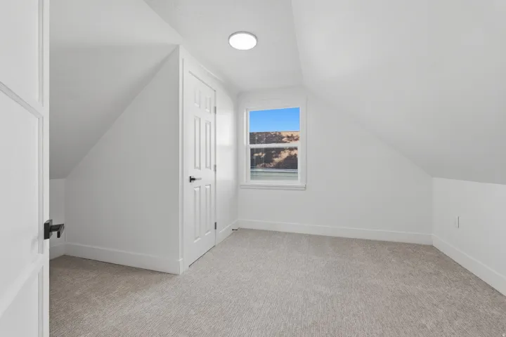 Neutral paint palette with carpeted flooring, a paneled door, and a single window
