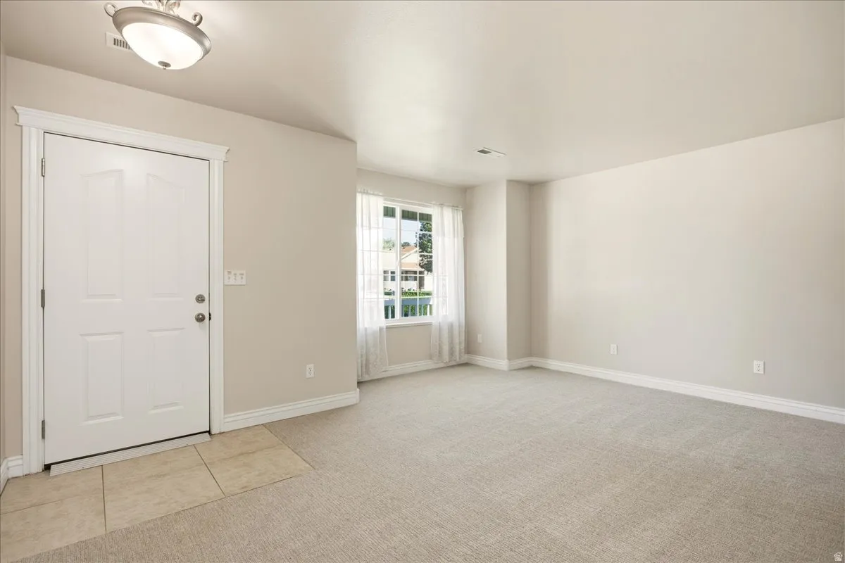 Recessed entry with tile flooring, neutral wall tones, and updated carpeting