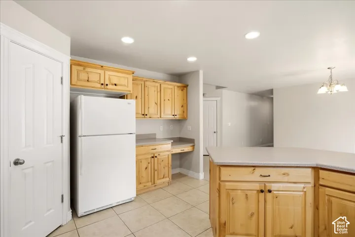 Kitchen featuring wood cabinetry, light-toned countertops, recessed lighting, and tile flooring