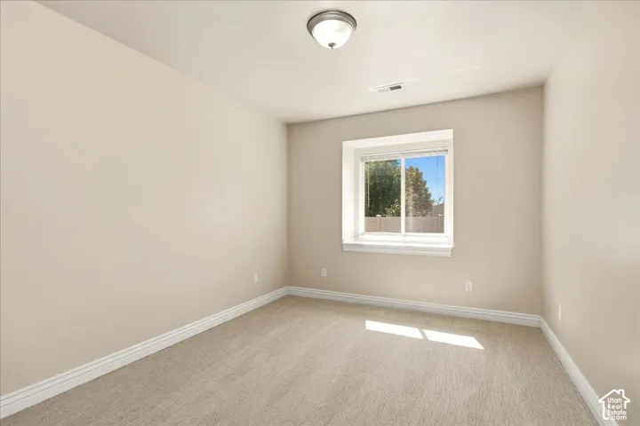Neutral tone wall paint, carpet flooring, white trim, recessed window, and a flush mount ceiling light