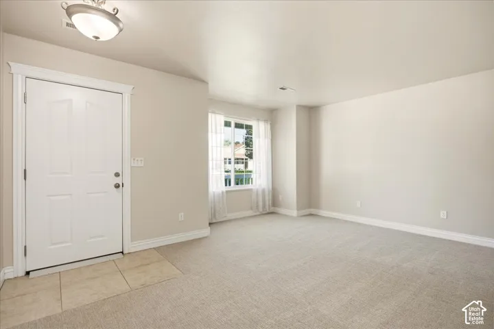 Recessed entry with tile flooring, neutral wall tones, and updated carpeting