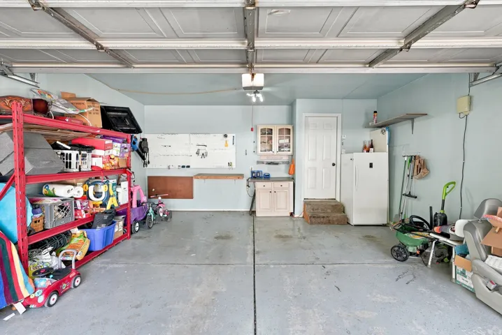 Garage space featuring a concrete floor, built-in cabinetry, and overhead lighting