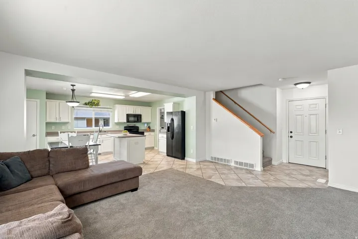 Kitchen with white cabinetry, a center island, and black appliances