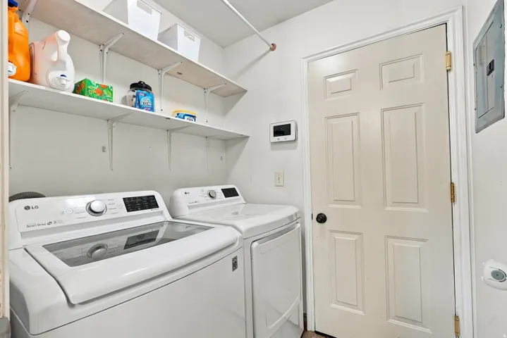 Dedicated laundry area with built-in shelving and a panel door