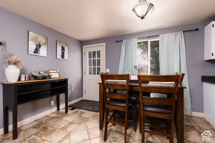 Recessed lighting, window with light-toned drapes, paneled door with windowpanes, and tile flooring