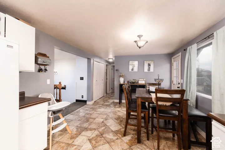 Kitchen and dining area featuring tile flooring, white cabinetry, a built-in window seat, and a ceiling-mounted light fixture
