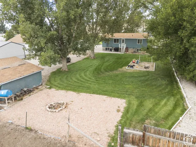Expansive lawn with mature trees and a dedicated fire pit area
